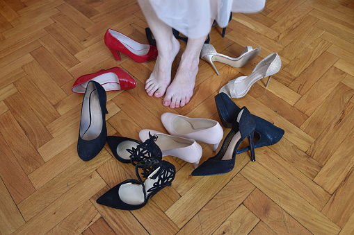 High angle view of bare woman's feet among high heels