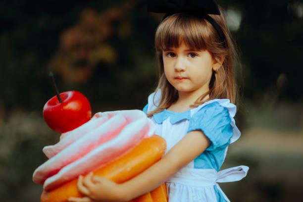 menina segurando um cupcake enorme no retrato do estilo da fantasia - little girls alice in wonderland child fairy tale - fotografias e filmes do acervo