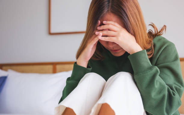 istock A woman sitting on the bed with feeling sad and stressed, sick and headache 1696433648