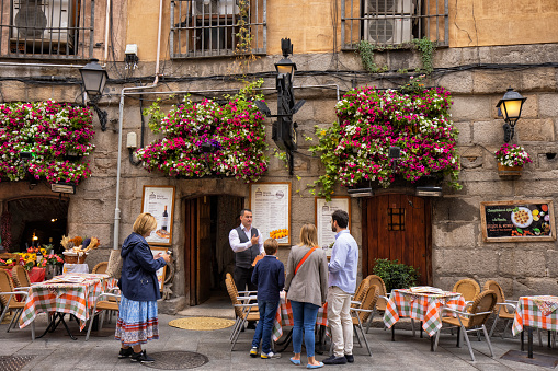 Man talking to his potential customers in front of a restaurant in Madrid, Spain.