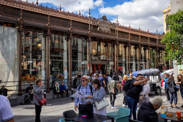 Crowd of people in the street outside of Mercado de San Miguel, Madrid, Spain.
