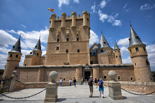 Exterior view of the Alcazar of Segovia, Spain. Tourists on the way visiting the Castle.