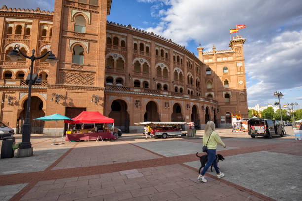 Woman walking dog outside the ring in Madrid, Spain. Plaza de Toros de Las Ventas is the largest bullfighting ring in Spain.