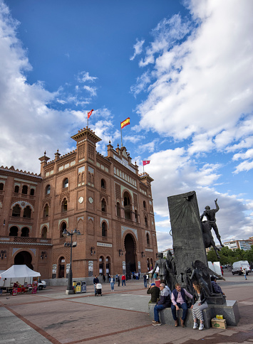 Exterior view of the ring in Madrid, Spain. Plaza de Toros de Las Ventas is the largest bullfighting ring in Spain. People sitting under  the statue of Jose Cubero (EI Yiyo).