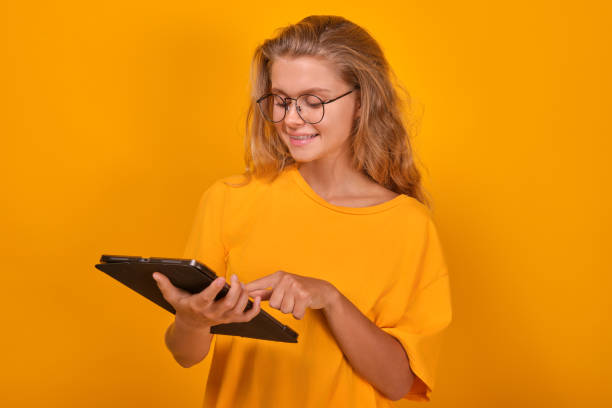istock Young positive Caucasian woman uses tablet computer for educational purposes 1696470582