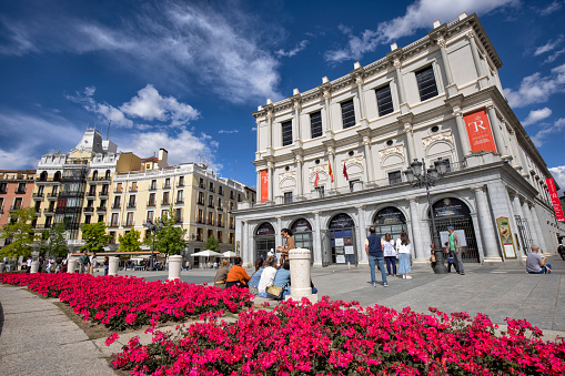 Street view of Plaza de Oriente, Madrid, Spain. The Royal Theater in front of flowerbeds.