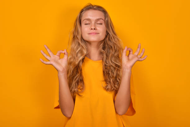 istock Young serene Caucasian woman makes meditative yoga gestures stands in studio 1696473149