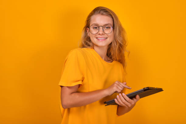 istock Young smiling pretty Caucasian woman with electronic tablet in hands 1696474203