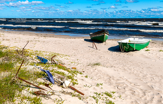 Coastal autumn landscape of the Baltic sea with anchored fishing boats on sandy beach
