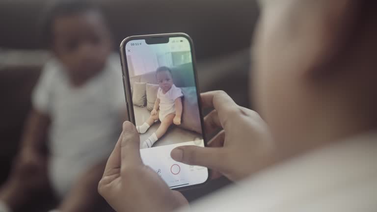 Single mom is taking photo of newborn at home.