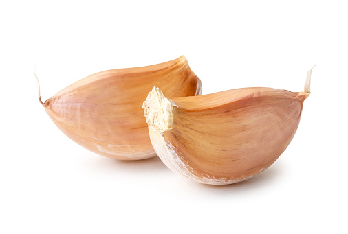 Two fresh unpeeled garlic cloves in stack are isolated on white background with clipping path.