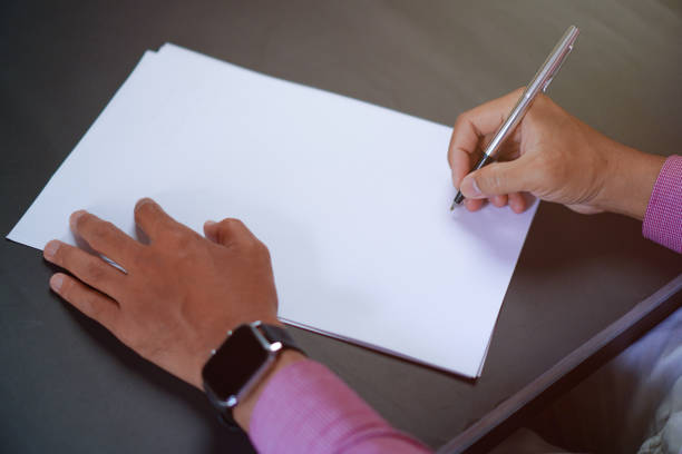 istock Man Holds a Pen and Ready to Write on Sheets of Paper, Writing Letter Concept 1696525493