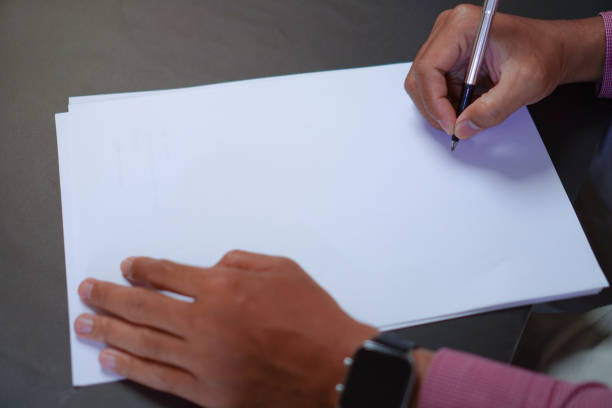 istock Man Holds a Pen and Ready to Write on Sheets of Paper, Writing Letter Concept 1696525498