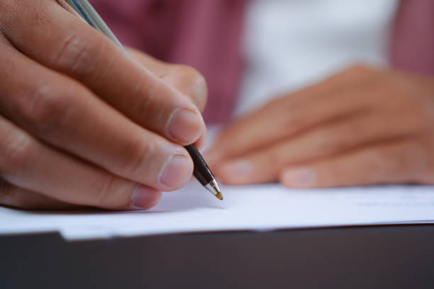 istock Man Holds a Pen and Ready to Write on Sheets of Paper, Writing Letter Concept 1696525506