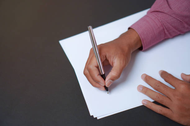 istock Man Holds a Pen and Ready to Write on Sheets of Paper, Writing Letter Concept 1696525508