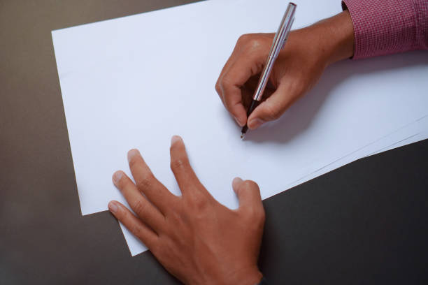 istock Man Holds a Pen and Ready to Write on Sheets of Paper, Writing Letter Concept 1696525514