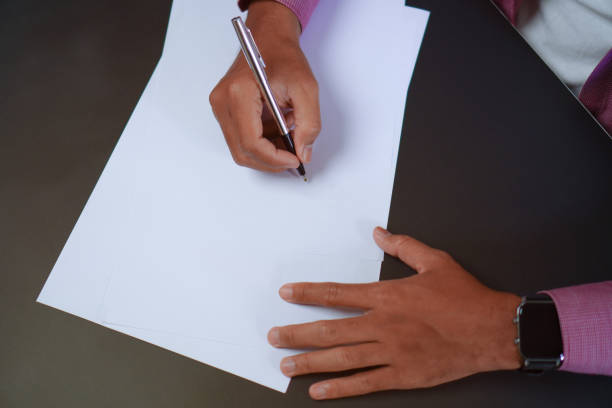 istock Man Holds a Pen and Ready to Write on Sheets of Paper, Writing Letter Concept 1696526027