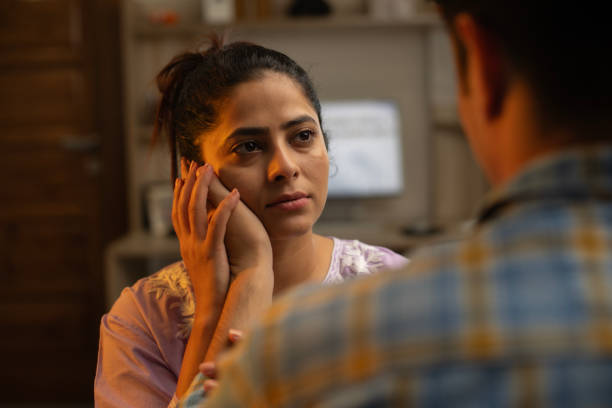 istock Husband touching wife's cheek and consoling her at home 1696530352