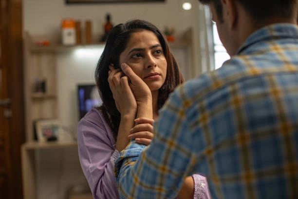 istock Husband touching wife's cheek and consoling her at home 1696531403