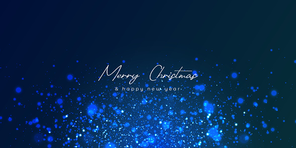 Blurred bokeh light on dark blue background. Christmas and New Year holidays template. Abstract glitter defocused blinking stars and sparks.