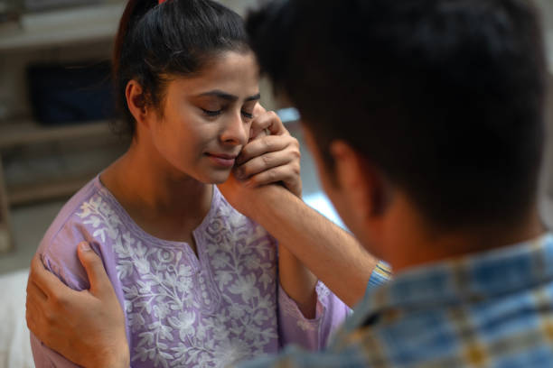 istock Husband touching wife's cheek and consoling her at home 1696555135