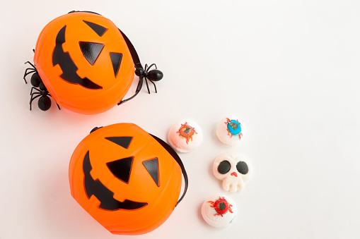 top view of halloween lollipops with spiders and webs in bowl