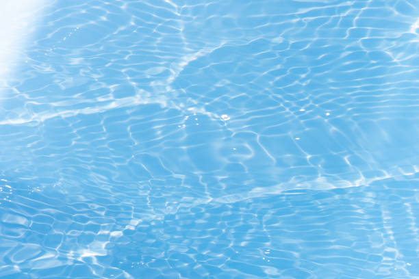 istock Defocus blurred transparent blue colored clear calm water surface texture with splashes reflection. Trendy abstract nature background. Water waves in sunlight with copy space. Blue watercolor shine. 1696569481