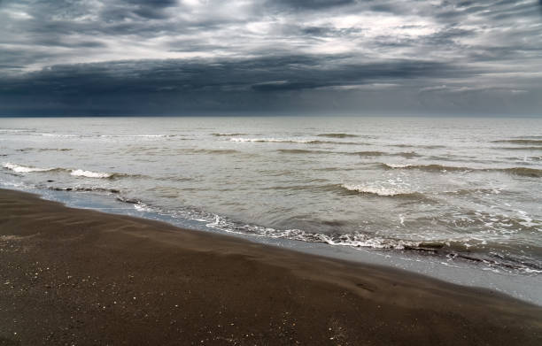 istock Sandy sea shore in cloudy weather with thunderclouds 1696579712