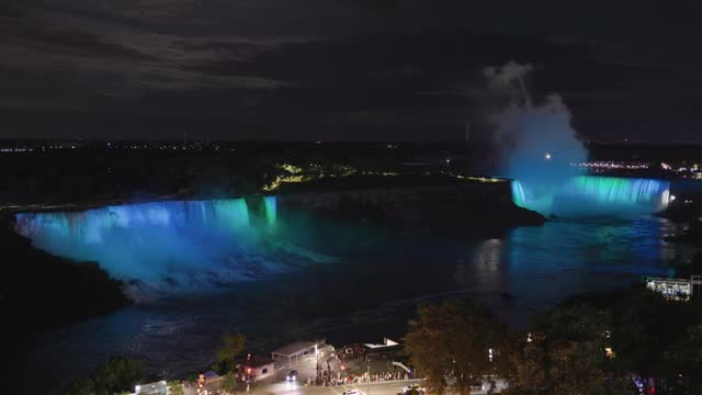 Elevated view of illuminated American and Horseshoe falls with rapid changing colors