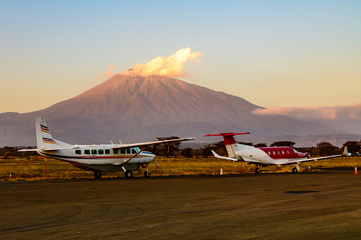 Small propeller airplanes at airport at sunset, mount Meru at background. Arusha, Tanzania