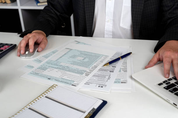 man completing tax form 1040. Tax time man completing tax form 1040. Tax time, accounting concept Digital Permit Book vs. Traditional Paper Systems stock pictures, royalty-free photos & images