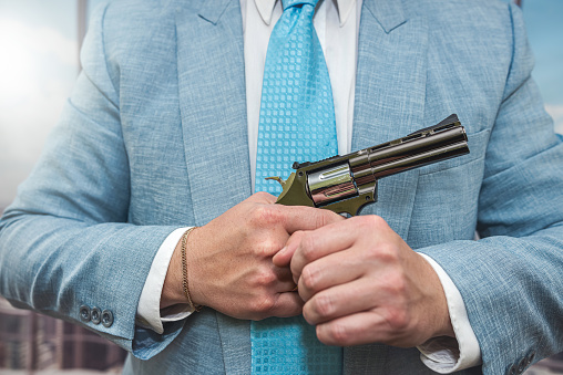 closeup agent in blue suit holding semi-automatic pistol gun. ganster or killercloseup agent in blue suit holding semi-automatic pistol gun. gangster or killer