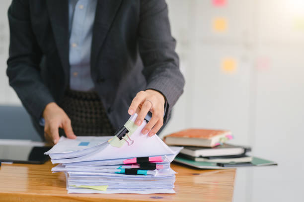 istock An advisor in financial business analytics, a woman is analyzing data charts, graphs, and financial reports on stacks of papers, concept of data analysis. 1696646602