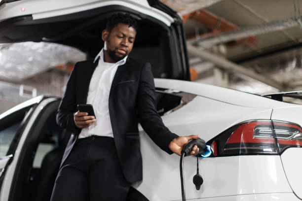 istock Employee with mobile starting EV charging session in parking 1696649364