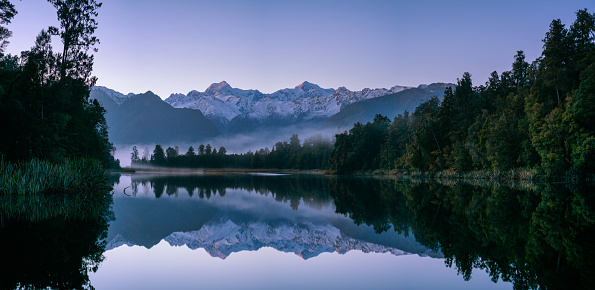 panoramic landscape with lake at springtime in front of mountain range