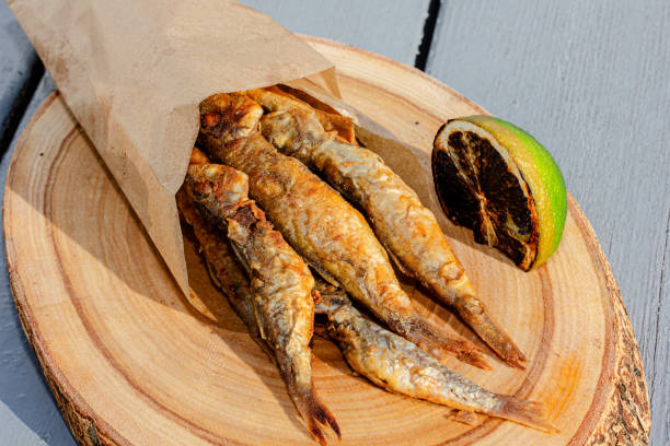 istock Fried small fish mullet whith souse and lemon on white 1696733820