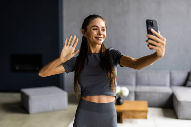 istock Attractive healthy young woman using mobile phone at the yoga studio 1696734363
