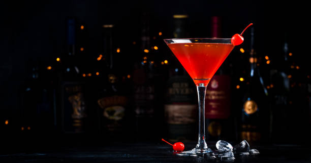 манхэттенский коктейльный напиток с бурбоном, красным вемутом, биттером, льдом и вишней в бокале, темным фоном барной стойки, барными инстр� - manhattan cocktail cocktail drink cherry стоковые фото и изображения