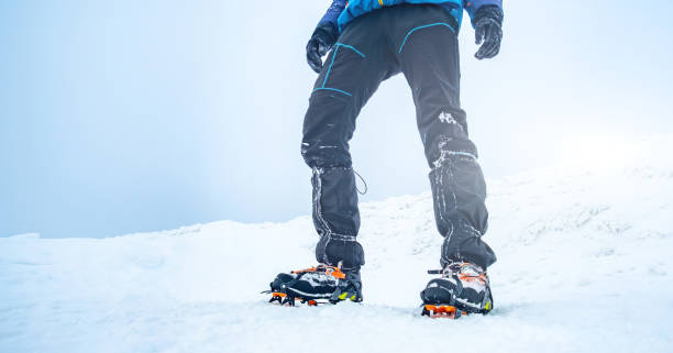 istock Man trekking snowy mountain using crampons 1696751714