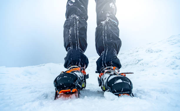 istock Man wearing crampons standing on snow 1696751716
