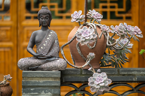 Bronze buddha statue against temple facade in Daci temple, downtown Chengdu, Sichuan province, China