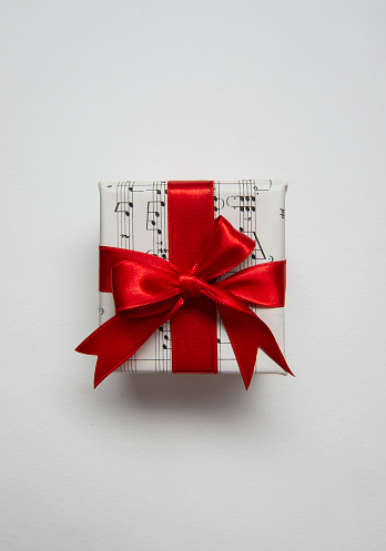 The gift box covered with musical note paper on white background.