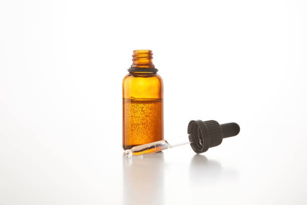 istock Black cap with pipette lies on open brown glass bottle. 1696767133