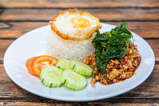 Spicy fried pork with basil leaves, the famous traditional Thai food served with jasmine rice and fried egg.