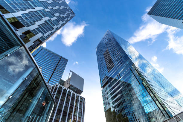 Modern building in the city with blue sky Low angle of modern highrise building with reflection glass in the city wth blue sky office building stock pictures, royalty-free photos & images