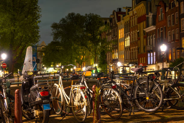 istock Parked Bicycles and Scooter in Amsterdam at Night 1696789506