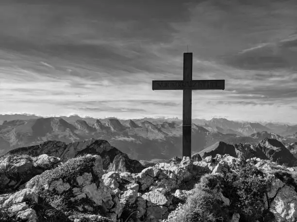 Photo of Summit cross black and white. Religious cross on the highest point of a mountain. Freedom through God. High quality photo