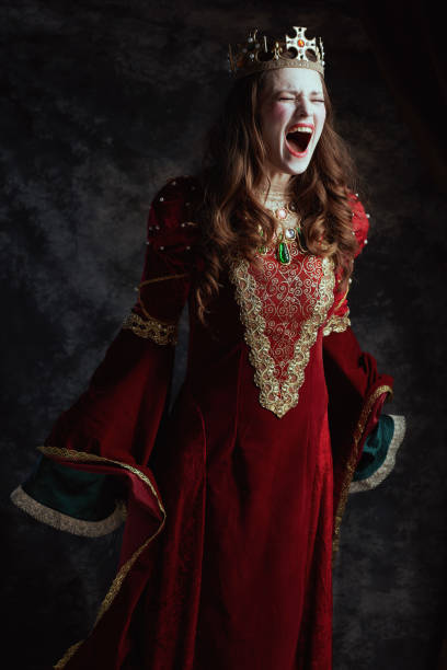istock mad medieval queen in red dress with white makeup and crown 1696823622