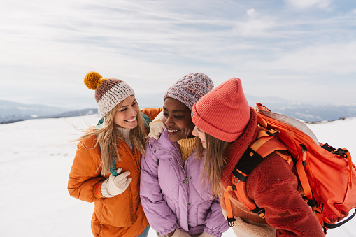 Photo of a group of female friends climbing the snowy mountain