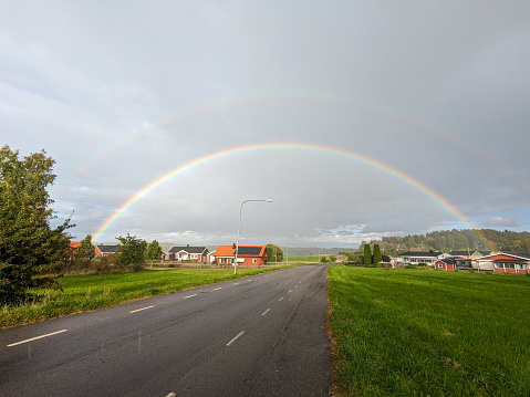 Scenic view of rainbow over road against sky